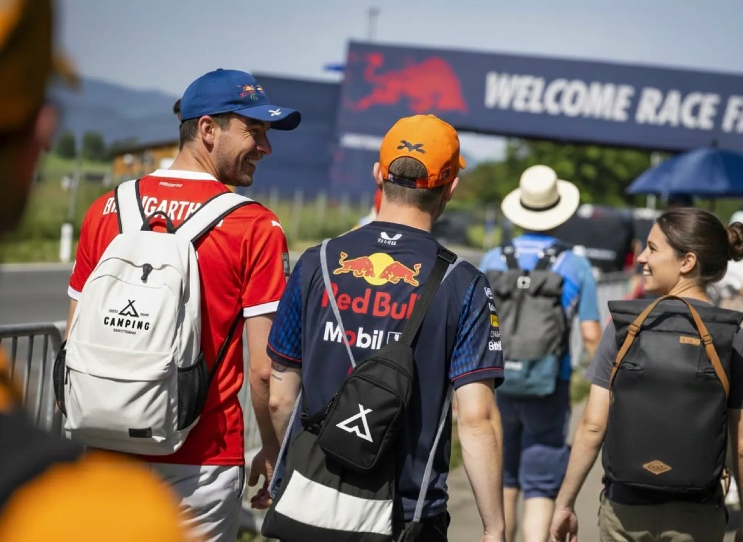 Gäste gehen die 900 m vom Campingplatz zum Red Bull Ring — mit Schitterhof-CAMPING-Rucksack